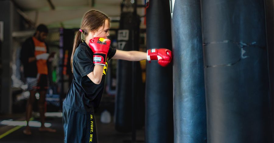 Child practicing kickboxing techniques during Kickboxing Classes For Kids at Train Fight Win